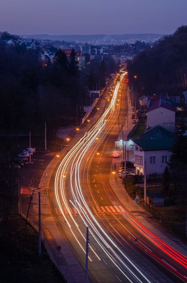 Long exposure of a busy road in Lviv at night showcasing dynamic light trails.